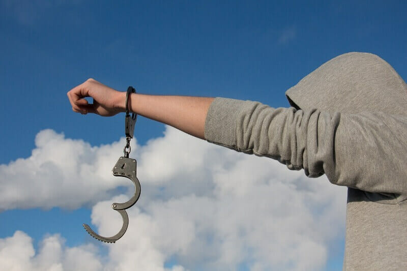 man with handcuffs half open on hand before him